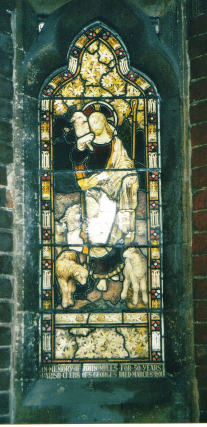 Stained glass window showing Jesus Christ with sheep, with inscription at the foot