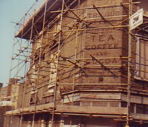 Corner property with scaffolding, old signage visible
