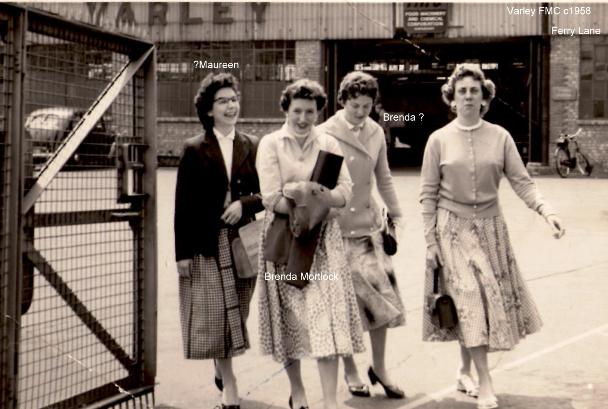 Four young women walking through the factory gates