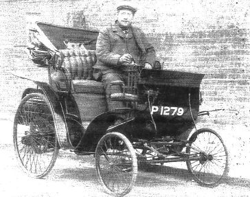 Early 20th century 2-seater car, front wheels smaller diameter than rear, with driver Thomas Dear