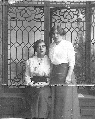 Mary Ellen Ryan (standing) with female work colleague in front of ornate leaded window