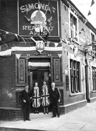 Two couples standing outside the Royal Tar, bunting, flags, Union Jack aprons for the ladies, celebrating King George VI coronation 1937