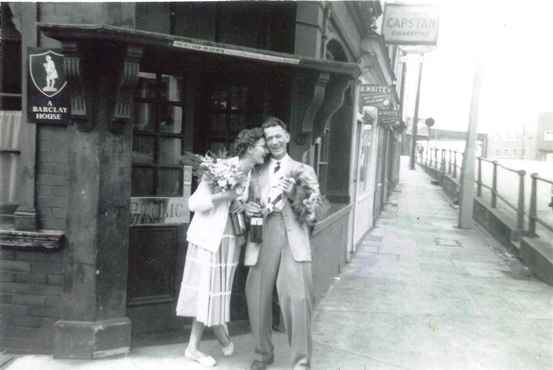 Happy couple with flowers outside a pub
